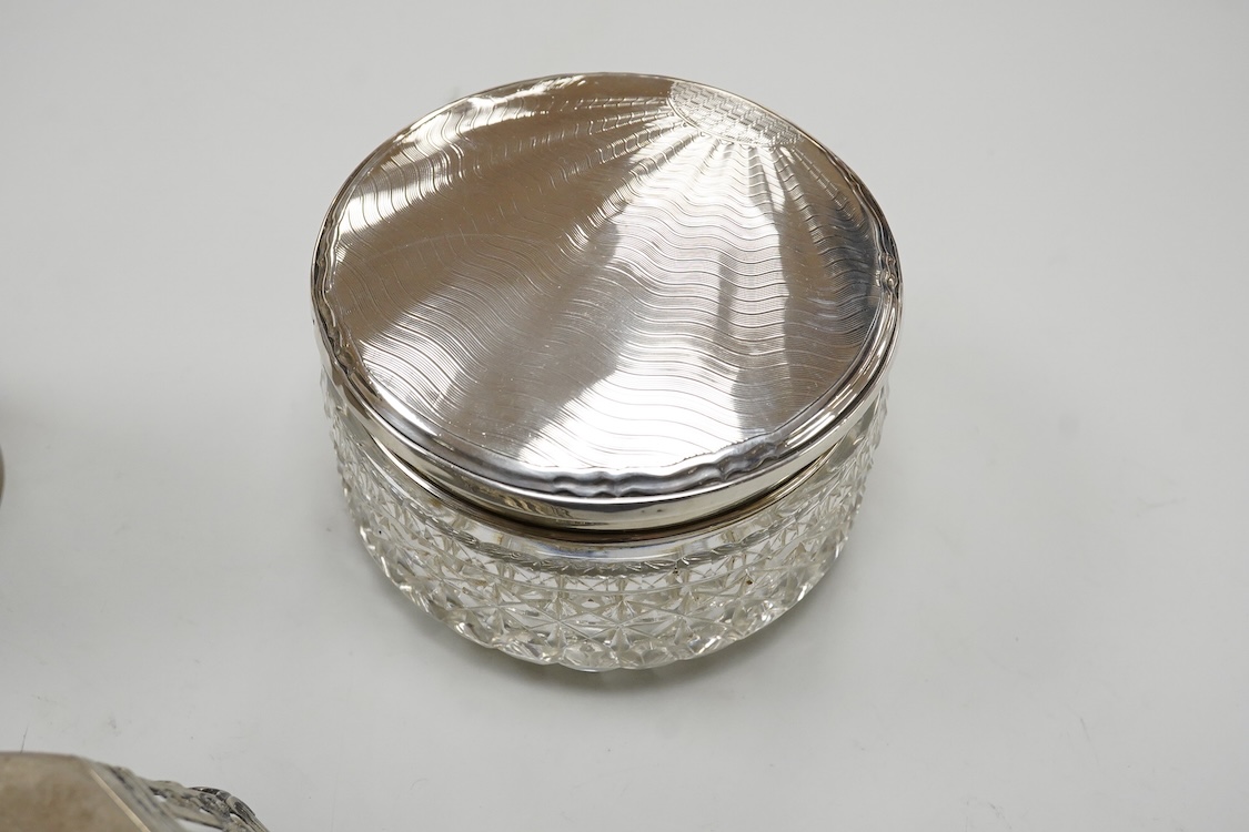 A German pierced 800 standard white metal bowl, 21.2cm, an engine turned white metal cigarette canister and a silver mounted glass dressing table pot.
